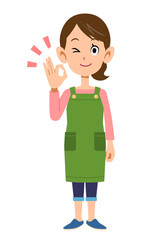 OKのサインを示すエプロンをつけた女性の全身
