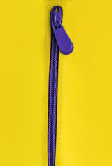 Bright buttoned purple zipper on a yellow background. Flat lay. © kvladimirv