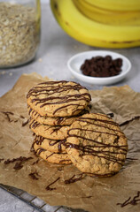 banana oatmeal cookies with chocolate chips, bananas and oats in background