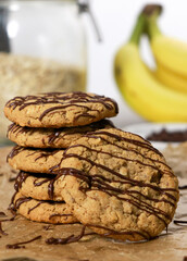 banana oatmeal cookies with chocolate chips, bananas and oats in background