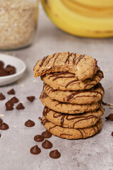 banana oatmeal cookies with chocolate chips, bananas and oats in background