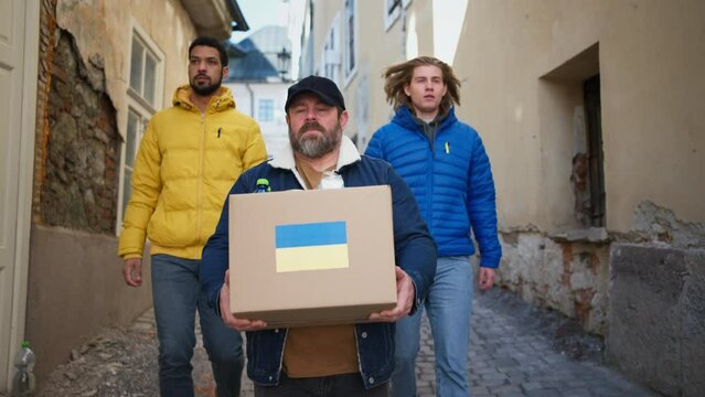 Team of volunteers collecting boxes with Humanitarian aid for Ukrainian immigrants in street