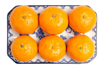 Fresh Organic Jeruk Baby Santang or Mandarin Baby Oranges, very sweet and juicy, serving on blue plate isolated on white background. Clipping path