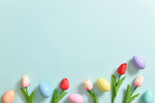 Background with rabbit ears, Easter eggs and tulip flowers. happy Easter. Decor for the feast of Holy Easter. Space for copying. Flat position, top view.
