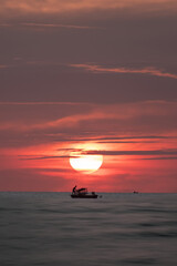Fishermen set up their fishing gear against the background of a beautiful sunset.