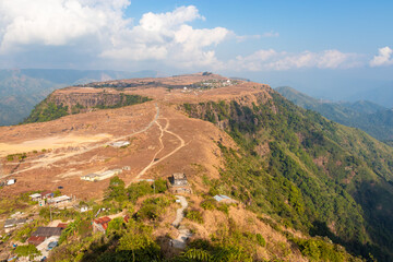 Fototapeta na wymiar small remote village on mountain top flat bed with bright sky at morning from top angle