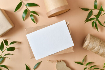 Kraft envelope with eco-packaging and leaves on a beige background. Zero waste. A lifestyle without plastic. Copy space. Flat lay, top view.