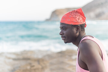 black man looking at the sea enjoying the good weather