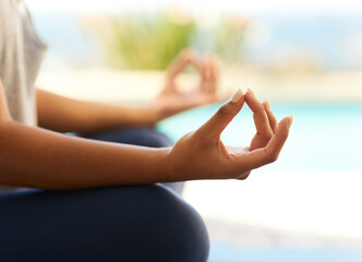 Finding balance. Cropped shot of an unrecognizable young woman meditating outdoors.