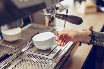 Fototapeta na wymiar Young woman barista using coffee machine in cafe