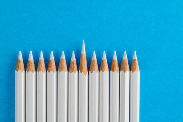 One white color pencil standing out from the crowd