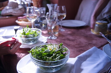 Rustic table served for dinner with fresh salad in front