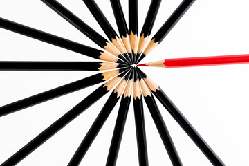 One red pencil standing out from the black pencils