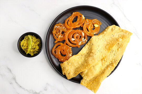 Popular Indian sweet Jalebi and Fafda served with Sambhara. Gujarati snack is mostly eaten during Indian Festivals such as, Gudi Padwa, Dussehra, Eid, Diwali, Mahashivratri, Holi. with Copy space. 