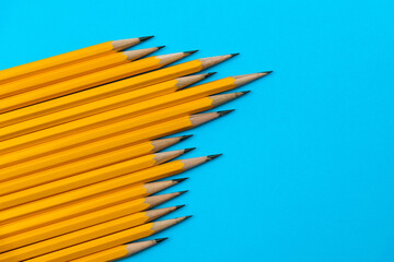 A row of yellow pencils on blue background