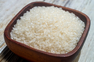 close up of japanese rice in a wooden cup. Japonica rice grains. sometimes called sinica rice, is one of the two major domestic types of Asian rice varieties.