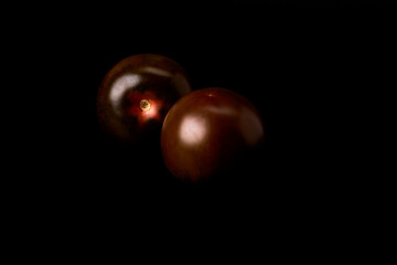 Tasty tomato on a black background. Healthy and vegetarian food