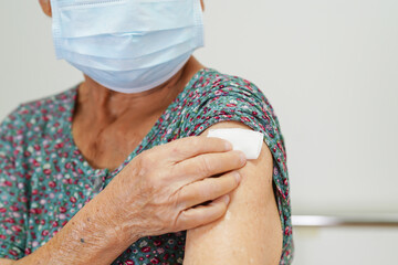 Asian elder senior woman with protective face mask getting vaccine for protect corona virus.