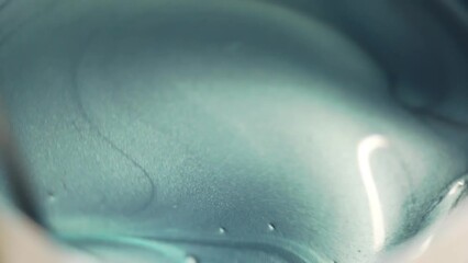 Close-up of a metallic blue paint being stirred together