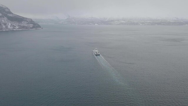 Ferry en route from Olderdalen to Lyngseidet on foggy Kaafjord, Norway; drone