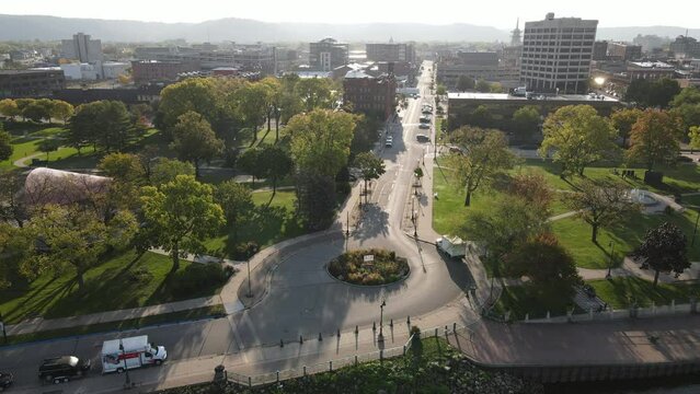 Panorama of downtown area from park, to buildings, to the Mississippi River and bridge crossing in La Crosse, Wisconsin, in summer. Hazy summer sky with bluffs seen in all directions. 
