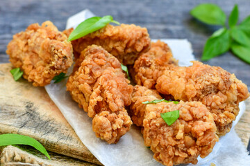 
 Crispy  deep fried   Chicken    strips and Wedges potato. Breaded  with cornflakes chicken  breast fillets  with chilly peppers and fresh   basil on wooden rustic background