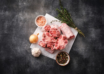 Meat for bull tail stew over on dark blackboard. Fresh raw oxtail cut.  Rustic style.