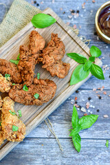 
 Crispy  deep fried   Chicken    strips and Wedges potato. Breaded  with cornflakes chicken  breast fillets  with chilly peppers and fresh   basil on wooden rustic background