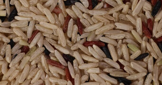 Mixed low glycaemic index healthy rice grain basmati millet buckwheat red rice heap Macro closeup rotating