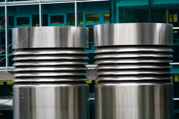 Close-up of shiny metal tubes of air ventilation system of modern office tower at City of Geneva on a cloudy spring day. Photo taken March 18th, 2022, Geneva, Switzerland.