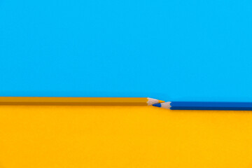 Two colored pencils divide an area into two