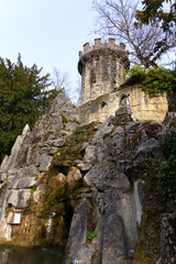 Fototapeta na wymiar Stone tower in Neo-Gothic style at park named Parc de mon Repos at City of Lausanne on a blue cloudy spring day. Photo taken March 18th, 2022, Lausanne, Switzerland.