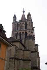Fototapeta na wymiar Medieval Cathedral Notre Dame at the old town of Lausanne on a blue and gray cloudy spring day. Photo taken March 18th, 2022, Lausanne, Switzerland.