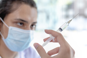 Doctor holding a syringe containing a respiratory viral vaccine or anti-influenza medication, Research and covid19, Pandemia, Infectionist, Doctor holding a vaccine against COVID-19 in the hospital.