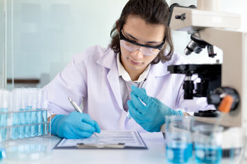 Fototapeta premium Laboratory diagnosis of synthetic substances, Scientist or researcher examines the substance in vitro and record information, Lab experiments, Researchers scientist working analysis with test tube.
