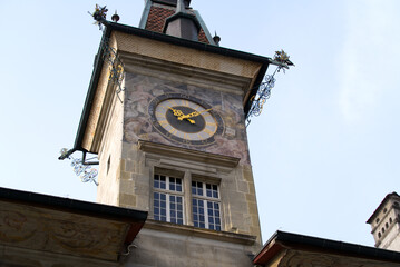 Fototapeta na wymiar Close-up of clock tower of city hall of Lausanne at Square named Place da la Palud at the old town of Lausanne on a cloudy spring day. Photo taken March 18th, 2022, Lausanne, Switzerland.