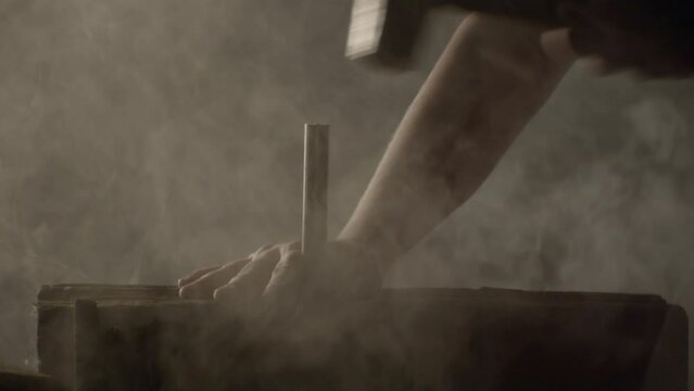 Hammer hitting a big nail in a dramatic misty ambience