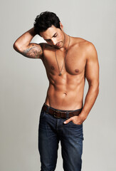 Naklejka premium Bare-chested and hunky. A muscular young man standing shirtless with his hand in his pocket.