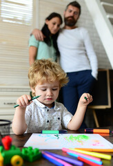 Kid learning painting, little artist painting, drawing. Happy family of three having fun together. Cheerful parents playing with son. Father mother and child drawing together at home.
