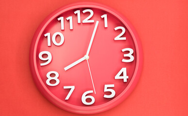 Fototapeta na wymiar Closeup single clock hanging on red wall