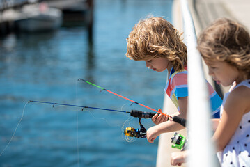 Kids friends fishing on weekend. Two young cute kids fishing on a lake in a sunny summer day....