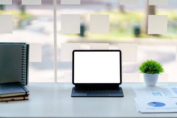 Tablet blank screen on desk and workspace background in modern office.