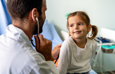 Pediatrician doctor examining little girl in a clinic