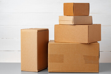 Group of cardboard boxes against white wooden wall