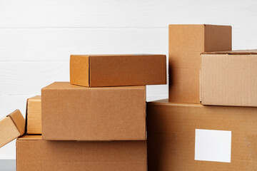 Group of cardboard boxes against white wooden wall