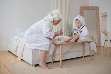 Mother painting nails to her daughter