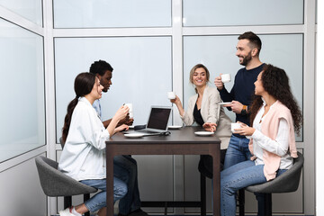 Team of employees enjoying coffee break together in office. Startup project