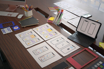 Above view digital tablet and website wireframe for mobile application on wooden table.