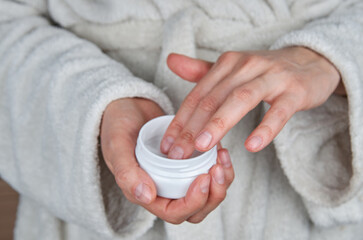 Woman hands with hand cream. Get cream from container