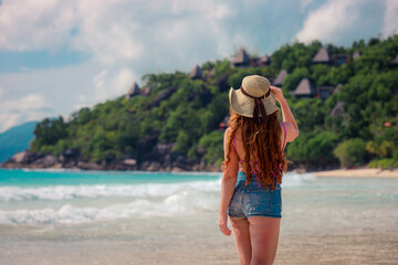 A girl in a hat on a beautiful paradise beach